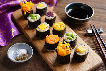 Vibrant Vegan Sushi Rolls: Colorful Food Photography of Delicious Quinoa & Vegetable Sushi on Wooden Board with Soy Sauce and Chopsticks.