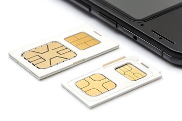 Gold chip sim cards near black smartphone mobile phone technology