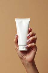 Woman's hand holding a white cosmetic tube. Skincare or beauty product mockups. Ideal for beauty branding, product advertisements, and mockup presentations