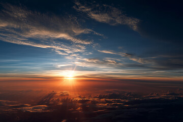 Fototapeta premium Sun setting over clouds seen from above with bright orange rays and deep blue sky sunset sunrise