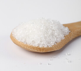 Yunnan white sugar displayed on a wooden spoon illustrating fine texture of sugar cane product