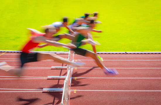 sportsman crossing the hurdles during a competion