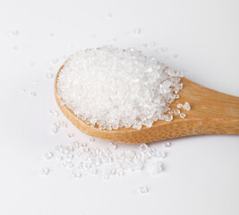 Yunnan milky sugar white bottom fine sugar displayed on a wooden spoon with scattered grains