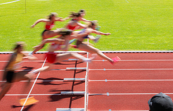 blurred image of women crossing the hurdles