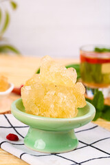 Yunnan ancient large yellow rock sugar cubes displayed in traditional bowl with herbal tea in charming setting