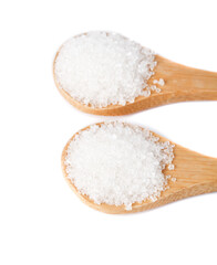 Fine white sugar from sugar cane displayed in wooden spoons against a white background