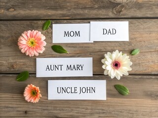 A warm arrangement of flowers and name labels on a wooden surface, representing family connections and love.