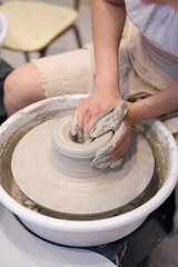 Potter creating ceramic vessel on pottery wheel in workshop