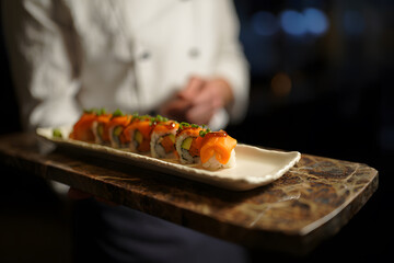 Chef Presenting Elegant Salmon Sushi Food Platter: Gourmet Japanese Cuisine