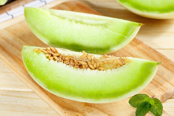 Fresh Shandong shallow bottom jade mushroom melon sliced and ready to enjoy on a wooden cutting...