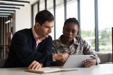 Team of diverse businessman and businesswoman discuss and working, brainstorming together with digital tablet on desk office in the office workspace