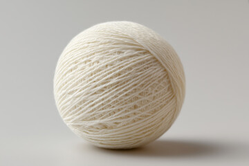 Creamy white yarn ball with visible texture and fine threads on a light gray background ball of yarn