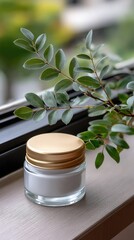 White ceramic jar with a gold lid resting on a windowsill, showcasing blurred natural scenery outside in a bright, serene atmosphere