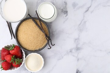 Different ingredients for panna cotta. Milk, sugar, vanilla and strawberries on white marble table, flat lay. Space for text