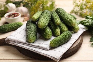 Making pickles. Fresh cucumbers on light wooden table, closeup