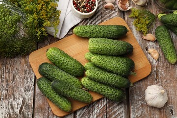 Making pickles. Fresh cucumbers and spices on wooden table, flat lay