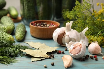 Making pickles. Fresh cucumbers and other ingredients on light blue wooden table, closeup