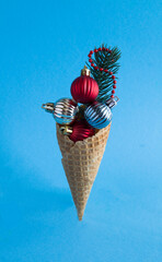 Ice cream cone with Сhristmas colored balls on a blue background. Close-up. Location vertical.