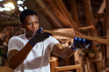 Professional African male carpenter is working professionally in sawmill - workshop.