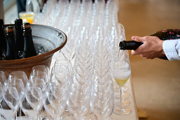 Close-up of a man pouring glasses of champagne at an event