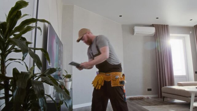 Wide angle shot of Caucasian male worker installing internet router and using digital tablet checking connection, copy space