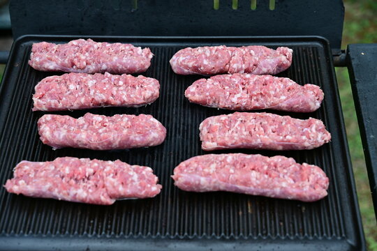 Close-up of Rows of sausages cooking on an outdoor barbecue