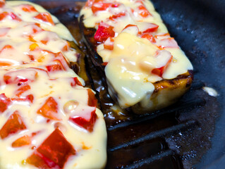 Delicious grilled dish topped with melted cheese and fresh diced peppers, served in a cast iron...