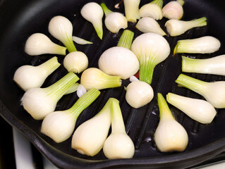 Sizzling white onions being grilled on a stovetop skillet for a flavorful cooking experience