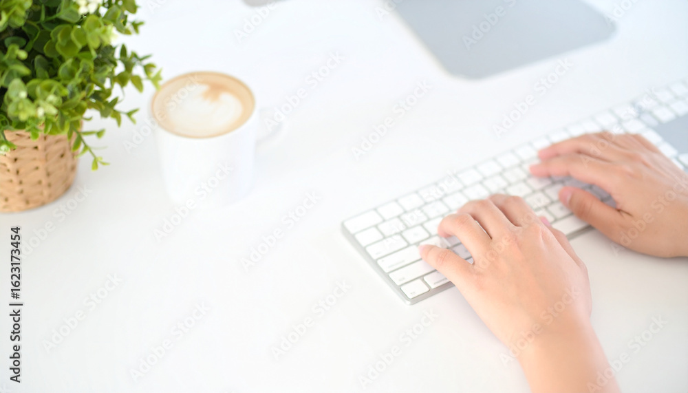 Poster hands on keyboard with coffee cup: a person is working with the keyboard at his working table with c