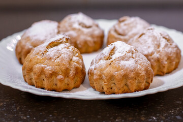 Freshly baked banana muffins elegantly arranged on a white plate, dusted with powdered sugar