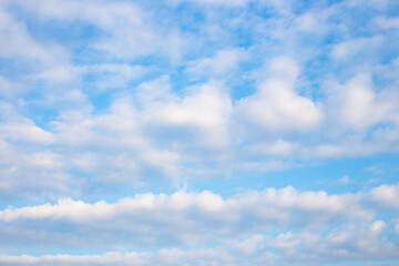 A wide expanse of blue sky with fluffy white clouds, creating a serene and peaceful scene