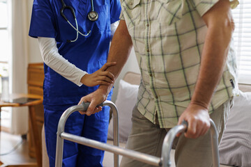 Caregiver, woman and helping with walker at nursing home for mobility support, physical therapy or...
