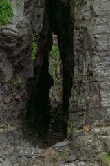 bering island. Narrow rocky canyon with steep walls covered in green vegetation, showcasing natural geological formations and textures, creating a dramatic and serene atmosphere in the wilderness