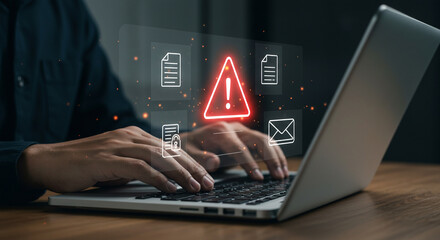 Alert triangle warning on a laptop, data security and cybersecurity issue.