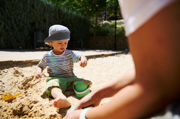 Young Child Playing in a Sandbox Outdoors on a Sunny Day