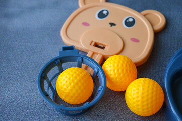 various colorful plastic toy parts laid out on a blue textile surface. components include a bear...