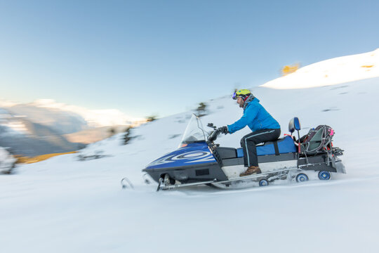 Snowmobile speeding through snowy winter landscape