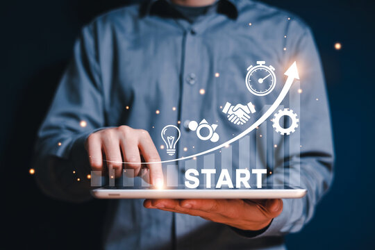 Digital Startup Business Growth and Development Concept Represented by Icons on a Tablet with a Rising Arrow and a Person Holding it