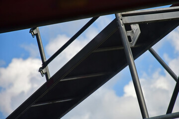 scaffolding on a house in a mirrow with claudy and blue sky
