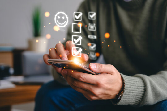 Person using a smartphone for online survey and checklist satisfaction application with glowing digital user interface elements reflecting customer feedback