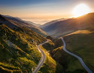 flying drone over valley at sunrise capturing aerial view of mountain landscape and winding road
