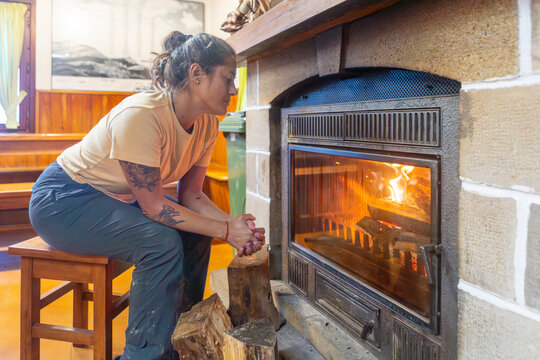Woman warming by the fire in a Gorbea Natural Park shelter