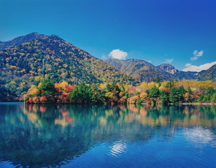 紅葉する湯の湖と山並