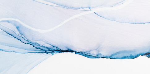 Obraz premium Beautiful patterns of blue alcohol ink flowing on a white canvas in a creative workspace