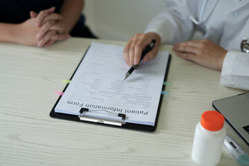 Young professional female doctor taking notes in journal, physician therapist practitioner filling...