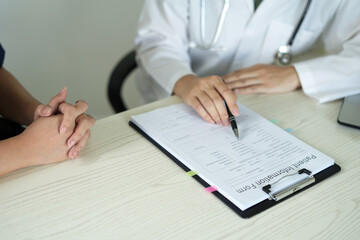 Young professional female doctor taking notes in journal, physician therapist practitioner filling...