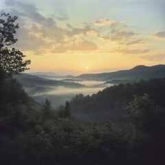 Misty valley at sunrise over rolling hills.