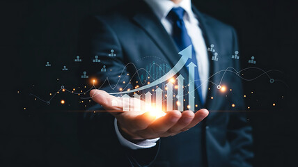 Businessman holding a glowing financial growth chart with upward trending arrow and digital data points
