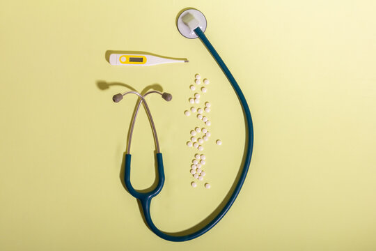 Medical equipment on light surface including pills