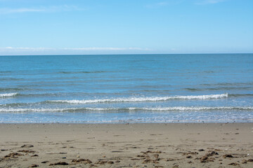 Serene Beach with Gentle Waves and Clear Blue Sky